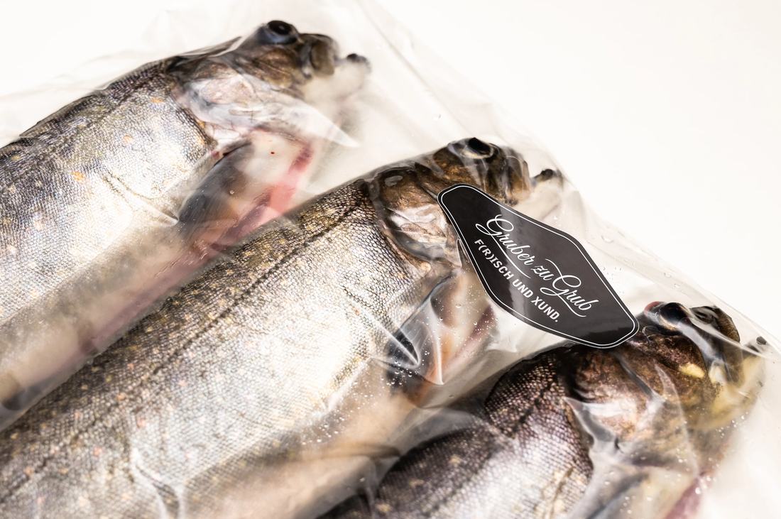 Frisch verpackte Forellen mit dem Etikett „Gruber zu Grub – Frisch und Xund“